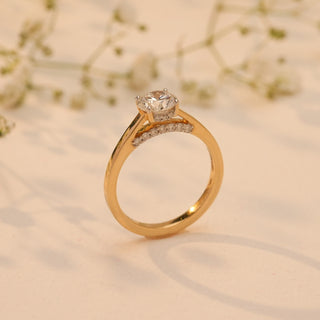 Side view of Reia's Golden Vow Solitaire Diamond Ring in 14KT yellow gold with a round-cut EF-VVS lab-grown diamond, captured on a soft beige floral background.