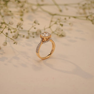 Side view of Reia's Crowned Radiance Diamond Proposal Ring in 14KT yellow gold, featuring an elevated round-cut EF-VVS lab-grown diamond on a pave band with floral accents.