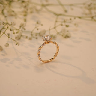 Side view of Reia's Lover's Knot Solitaire Diamond Ring in 14KT yellow gold with a twisted pave band and round-cut lab-grown diamond centrepiece.