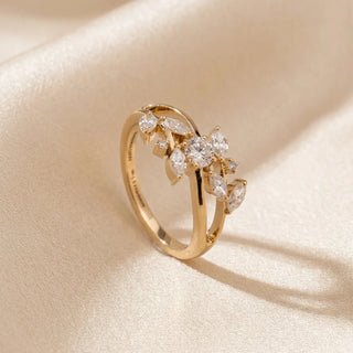 Angled view of a 14KT Yellow Gold ring with a round-cut diamond and marquise-cut diamond floral accents.