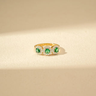 Close-up view of a Three-Stone Green Emerald Diamond Ring in 14KT Yellow Gold, featuring three vivid green emerald-cut gemstones.