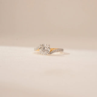 Side view of a 14KT Yellow Gold diamond ring, featuring a round centre diamond and diamond-set curved shoulders.