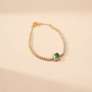 Top view of a round lab-grown diamond tennis bracelet in 14KT rose gold, featuring a square emerald centre stone framed by a diamond halo with a continuous row of round brilliant diamonds in an elegant design.