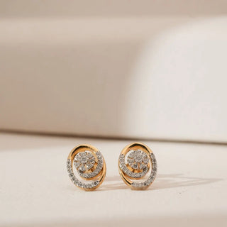Front view of yellow gold swirl diamond earrings featuring a floral cluster centre encircled by pavé-set lab grown diamonds, displayed on a soft neutral surface with subtle studio lighting.