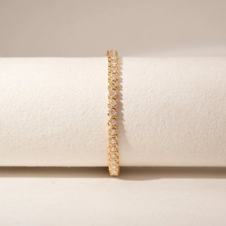 Front view of a 14KT Dual Gold diamond tennis bracelet featuring a continuous row of round diamonds in bezel settings.