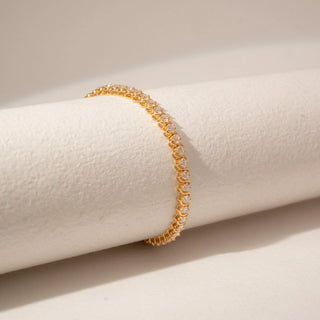 Side view of a 14KT Dual Gold diamond tennis bracelet featuring a continuous row of round diamonds in bezel settings.