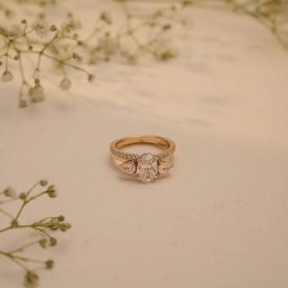 Top view of Reia's Golden Harmony Diamond Bridal Set, crafted in 14KT yellow gold with an oval-cut EF-VVS lab-grown diamond and pear-shaped sides, styled with floral accents.