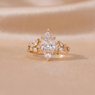 Front view of a 14KT Yellow Gold ring with a marquise-cut diamond and marquise-cut side diamonds.