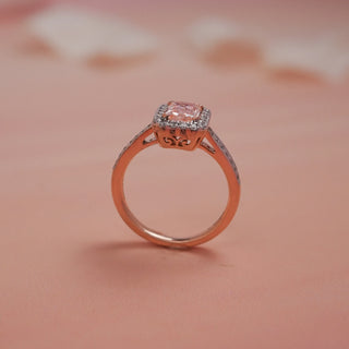 Model smiling with eyes closed wearing Reia Rose Halo Radiant Diamond Ring, radiating joy and elegance against a vibrant pink background, symbolising love, art, and brilliance.
