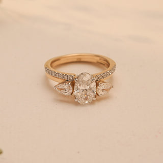 Top view of Reia's Golden Harmony Diamond Bridal Set, crafted in 14KT yellow gold with an oval-cut EF-VVS lab-grown diamond and pear-shaped sides, styled with floral accents.