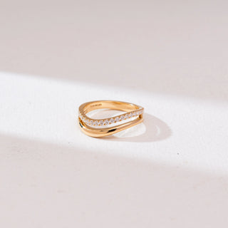 Front view of Wave Bypass Pavé Diamond Ring in 14KT yellow gold, showcasing overlapping curves with one band lined in round pavé diamonds for a sleek, elegant finish.