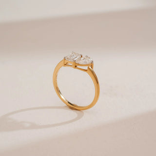 Side view of Reia’s 18 KT Yellow Gold Modern Twin Diamond Proposal Ring. Captured against a cream backdrop, the layout highlights the balanced silhouette of the Toi et Moi design.
