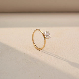 Angled view of a yellow gold solitaire ring featuring a round brilliant-cut diamond in a classic four-prong setting, highlighting its sparkle, elevated profile, and timeless elegance.