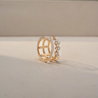 Angled view of a diamond wrap ring in 14 KT Yellow Gold, featuring pavé-set diamond bands and floral-inspired diamond clusters in an elevated open crossover design, displayed against a beige backdrop.