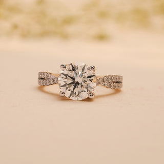 Front view of Reia's Crowned Radiance Diamond Proposal Ring, highlighting its elevated round-cut centre stone and shimmering pave detailing on the gold band.