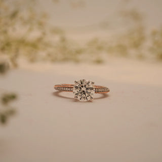 Front view of Reia's Golden Promise Round Diamond Ring in 14KT rose gold, highlighting its elevated round-cut diamond and dual pave detailing.