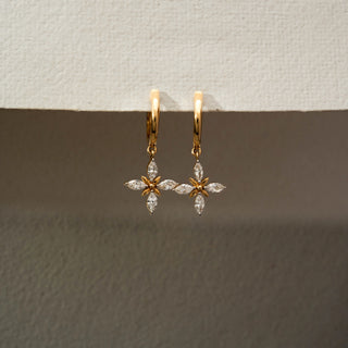 Front view of floral diamond drop hoop earrings in 14KT Yellow Gold, featuring marquise-cut lab-grown diamonds arranged in a cross flower motif. Captured against a beige backdrop, highlighting delicate sparkle.