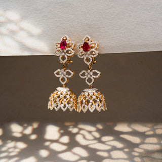 Side view of floral diamond jhumka earrings in 14 KT Yellow Gold, featuring ruby-toned pear stones, open floral motifs, and intricate lattice dome drops.
