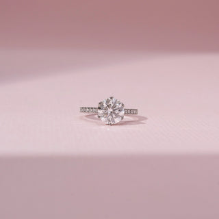 Front view of a solitaire diamond ring in 14KT white gold, featuring a round lab-grown diamond and pavé band.