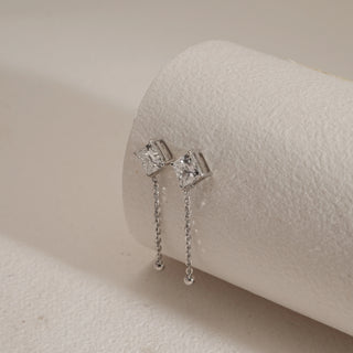 Side view of Solitaire Chain Drop Diamond Earrings photographed on beige background. Designed in 14KT hallmarked white gold, fitted with bombay screw closure. Diamonds are EF VVS lab grown, totaling 2.18 carats with a 1.09-carat solitaire. Product weight 2.94 grams, in INR 1,00,000–3,00,000 range.