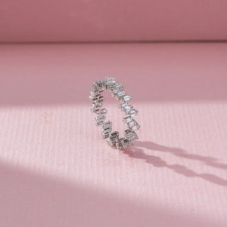Side view of Emerald Cut Diamond Band Ring in 14KT White Gold, featuring a continuous row of emerald-cut lab grown diamonds in prong setting. Set on a pink backdrop, the design highlights structure and brilliance.

