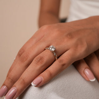 Reia's Lover's Knot Solitaire Diamond Ring worn on the hand, crafted in 14KT yellow gold with a pave-twisted band and shimmering round-cut lab-grown diamond.