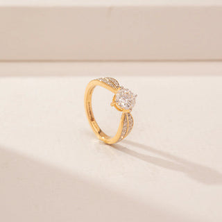 Angled view of a 14KT Yellow Gold diamond ring, featuring a round centre diamond and leaf-shaped diamond-set shoulders.
