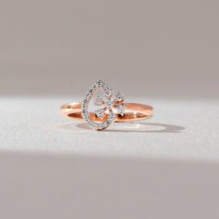 Front view of floral diamond ring in rose gold, featuring round lab-grown diamonds arranged in a blooming cluster within a teardrop frame lined with diamonds. Set on a soft neutral backdrop, it reflects delicate elegance.