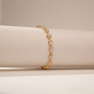 Angled view of a 14KT Yellow Gold diamond bracelet, featuring pear, oval and emerald-cut diamonds in a link design.