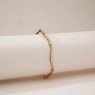 Side view of Golden Wave Radiant Diamond Bangle in yellow gold, featuring round lab-grown diamonds set along flowing wave-shaped lines, draped over a soft neutral display form.