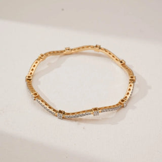 Top view of Golden Wave Radiant Diamond Bangle in yellow gold, featuring round lab-grown diamonds set along a flowing wave pattern with spaced diamond accents, displayed on a neutral surface.