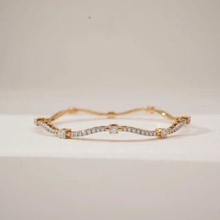 Front view of Golden Wave Radiant Diamond Bangle in yellow gold, featuring round lab-grown diamonds set along a flowing wave design with raised diamond accents, displayed on a neutral surface.