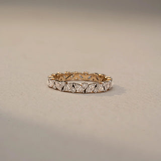 Front view of a diamond eternity band in 14 KT Yellow Gold, featuring alternating marquise-cut and round lab-grown diamonds in a continuous floral-inspired design, displayed against a beige backdrop.