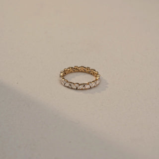 Top view of a diamond eternity band in 14 KT Yellow Gold, featuring alternating marquise-cut and round lab-grown diamonds in a continuous floral-inspired design, displayed against a beige backdrop.