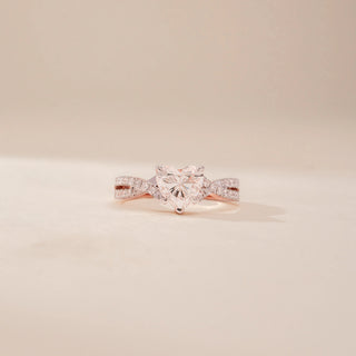 Front view of a 14KT Rose Gold diamond ring, featuring a cushion-cut centre diamond and diamond-set twisted shoulders.
