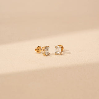 Angled view of emerald-cut lab-grown diamond stud earrings in 14 KT Rose gold, featuring four-prong emerald-cut solitaire diamonds in a timeless minimalist design.