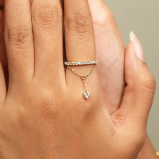 Front view of Diamond Chain Drop Ring in 14KT Yellow Gold, featuring a pavé band, delicate chain and heart-shaped diamond.