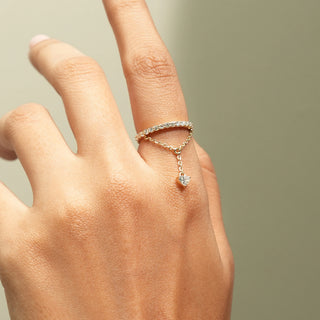 Close-up view of Diamond Chain Drop Ring in 14KT Yellow Gold, featuring a pavé band, delicate chain and heart-shaped diamond.