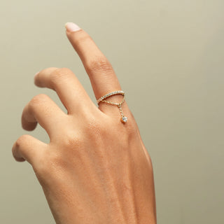 Side view of Diamond Chain Drop Ring in 14KT Yellow Gold, featuring a pavé band, delicate chain and heart-shaped diamond.
