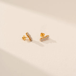 Angled view of Radiant Rounded Solitaire Ring in 14KT Yellow Gold, featuring a round lab-grown diamond on a beige backdrop.
