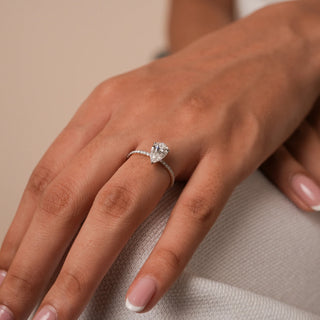Reia's Eternal Teardrop Solitaire Diamond Ring worn on hand, showcasing a pear-cut lab-grown diamond on a slim gold band, captured under warm light for an elegant bridal look.