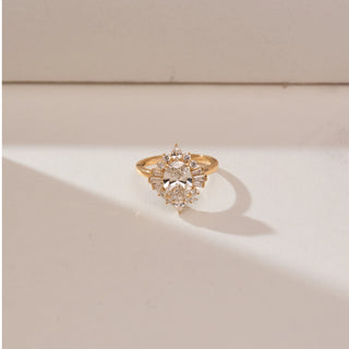 Top view of Oval Sunburst Deco Diamond Ring, 14KT yellow gold band featuring a central oval diamond with baguette, pear and round accents in a radiant Art Deco sunburst design.