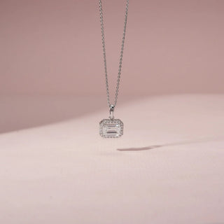 Front view of an emerald-cut diamond pendant in 14KT White Gold, featuring a diamond halo and a delicate chain.