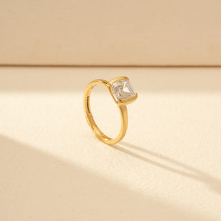 Angled view of Emerald-Cut Solitaire Diamond Ring in 14KT Yellow Gold, featuring a bezel-set emerald-cut diamond.