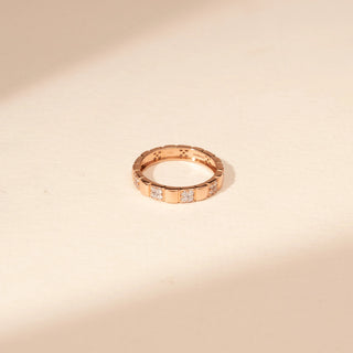 Top view of a 14KT Rose Gold diamond ring with alternating polished sections and rectangular diamond-set accents.