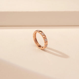 Angled view of a 14KT Rose Gold diamond ring with alternating polished sections and rectangular diamond-set accents.