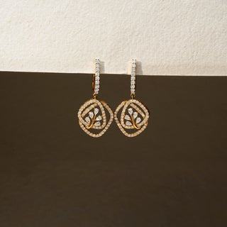 Front view of geometric diamond drop earrings in 14 KT Yellow Gold, featuring pavé-set circular frames with leaf-inspired diamond motifs against a neutral backdrop.