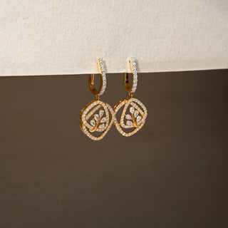 Side view of geometric diamond drop earrings in 14 KT Yellow Gold, featuring pavé-set circular frames with leaf-inspired diamond motifs and curved diamond hoops.