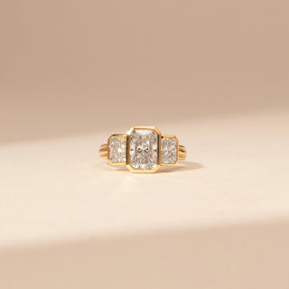 Front view of a 14KT Yellow Gold diamond ring with a rectangular centre diamond and two rectangular side diamonds in bezel-style settings.