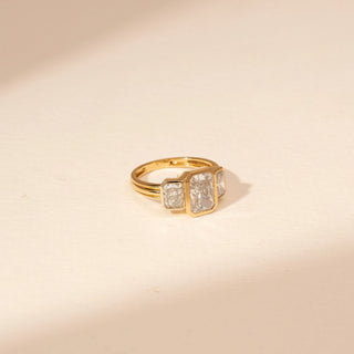 Side view of a 14KT Yellow Gold diamond ring with a rectangular centre diamond and two rectangular side diamonds in bezel-style settings.